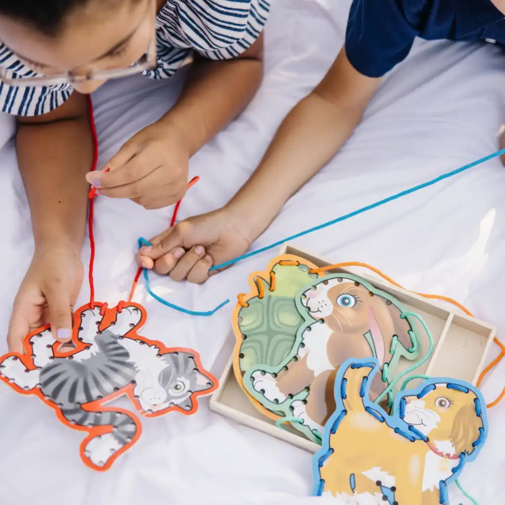 Amélioration de la motricité fine Motor grâce à un enfilage précis des lacets.